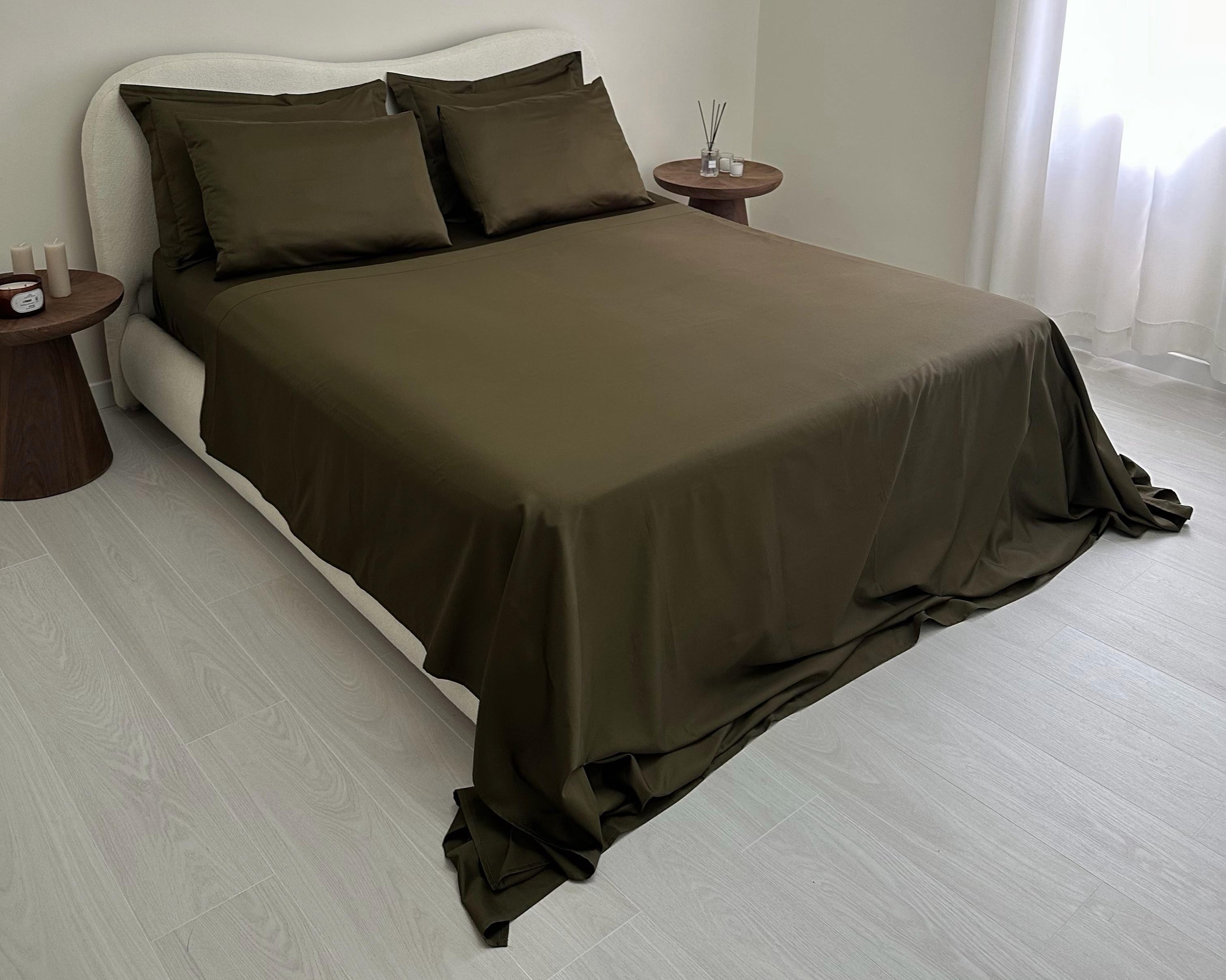 Brown bedspread and pillows on a bed in a minimalistic bedroom.