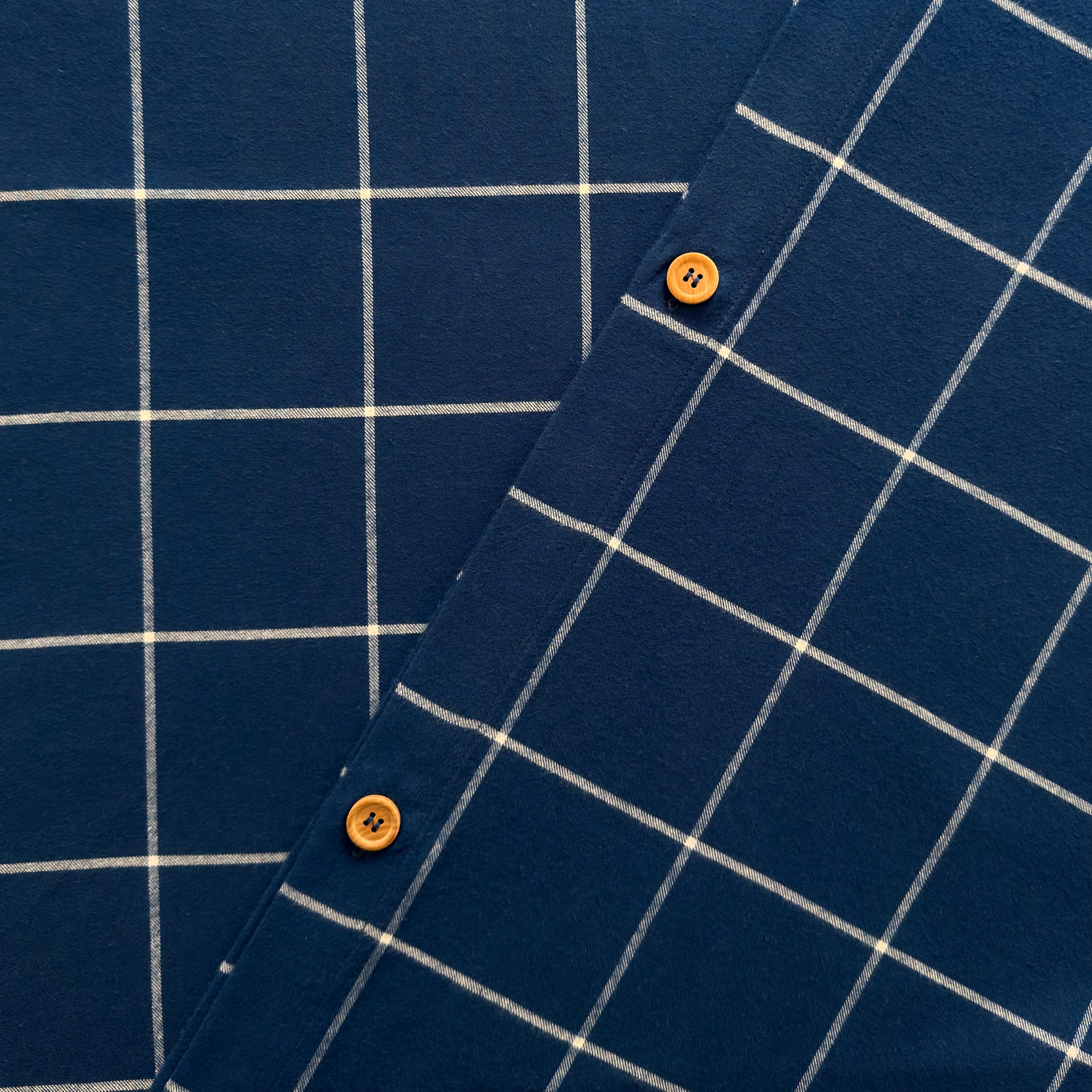 Navy blue fabric with white grid pattern and orange buttons