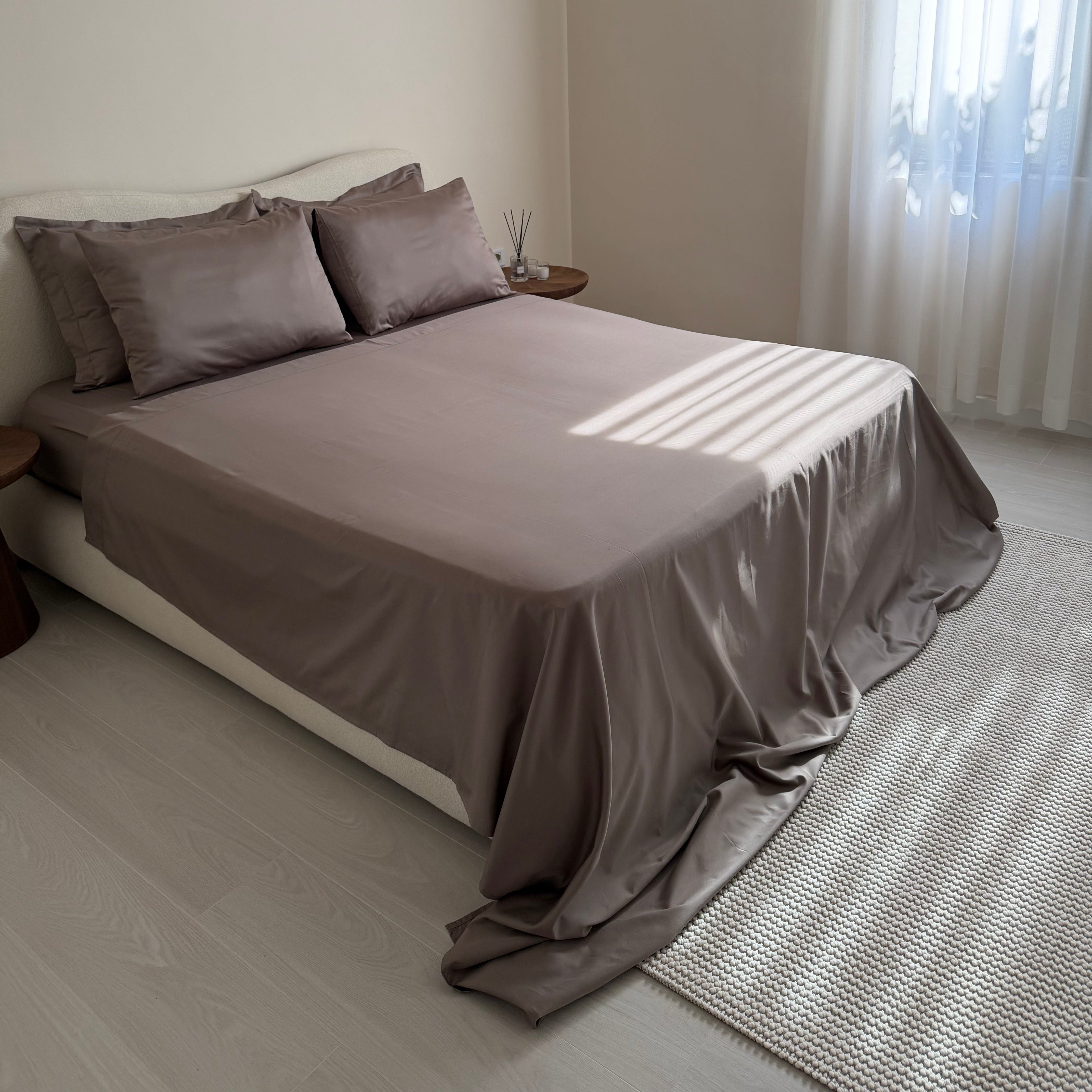 Bed with gray bedding in a minimalistic room