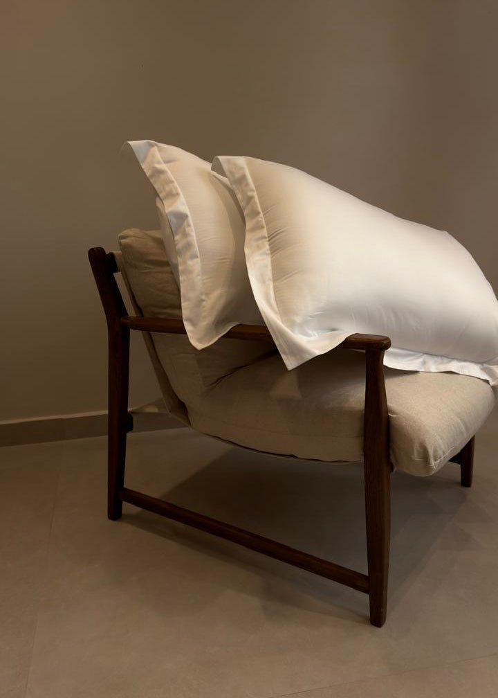 Chair with a blanket draped over it against a plain wall