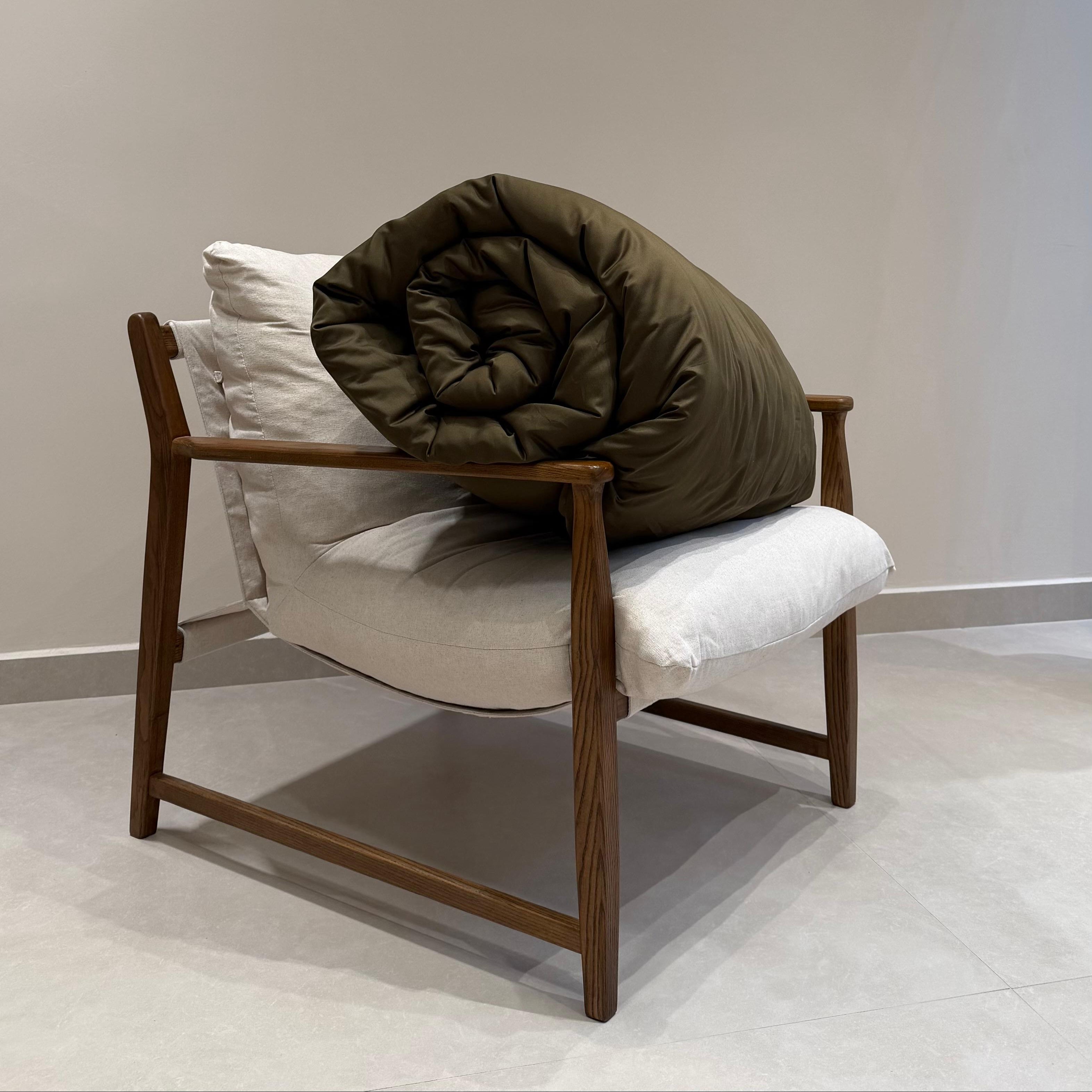 Brown quilt on a white chair against a plain wall
